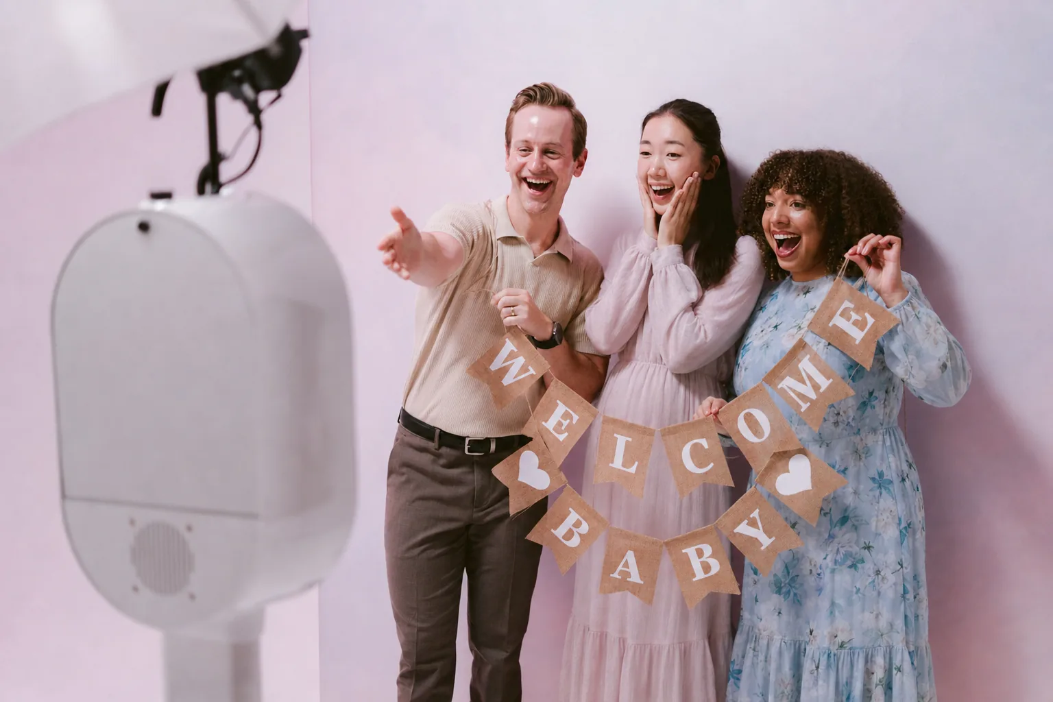 Family holding a welcome baby sign at the booth